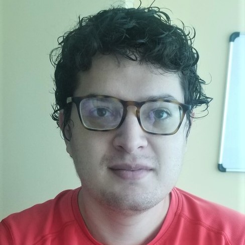la imagen puede contener a un hombre de cabello medio largo,tiene puestos lentes cuadrados y vestido de camiseta .